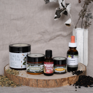 Collection of natural health products including teas, oils, and balms on a wooden stand with a neutral background.