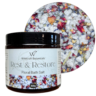 Bottle of Wildcraft Botanicals Rest & Restore Floral Bath Salt with a close-up of the product inside. Rest & restore.