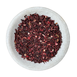 Dried hibiscus flowers in a white bowl on a white background