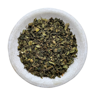 Dried stinging nettle in a white bowl on a white background