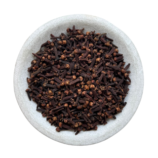 Cloves in a white bowl on a white background