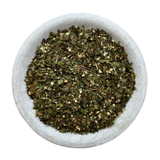 Dried hawthorn leaf in a white bowl on a white background