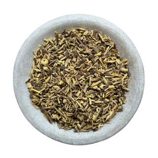 Dried licorice root in a stone bowl on a white background