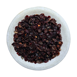Dried rosehip shells on a white plate with a white background